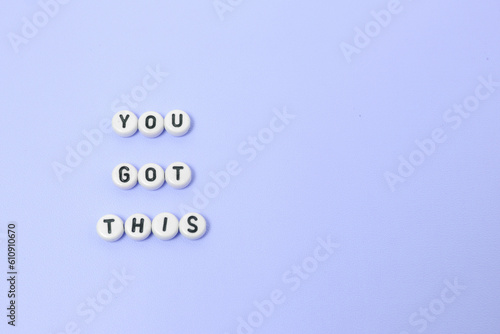 Top view of "you got this" quotes made out of beads on pastel background. motivation and success concept