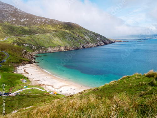 Keem bay and beach and Cliffs, Achill island, County Mayo, Ireland. Popular travel area with stunning nature scenery. Warm sunny day, cloudy sky. Irish tourism. Beautiful ocean view. photo