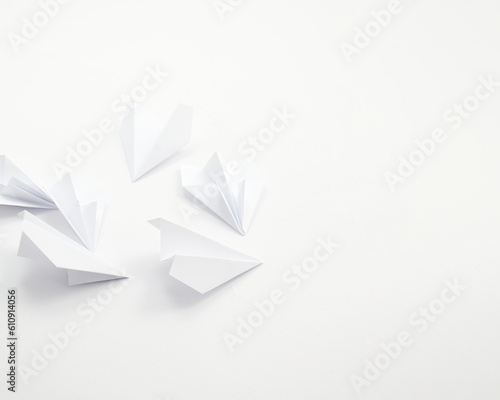 White paper airplanes on a white background.Space for text