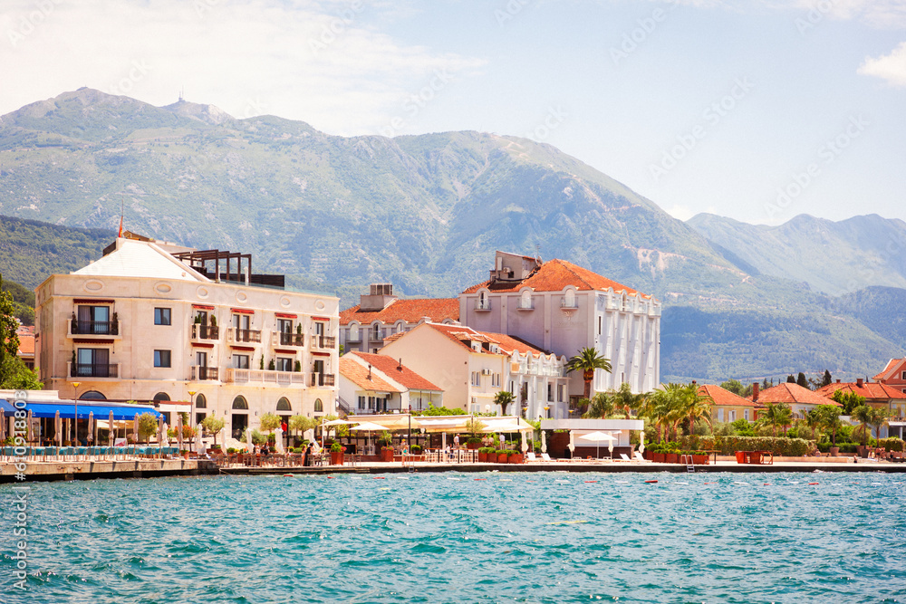 View from sea to sunny European town. Mountains in background. Travel and summer. Copy space
