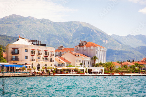 Fototapeta Naklejka Na Ścianę i Meble -  View from sea to sunny European town. Mountains in background. Travel and summer. Copy space