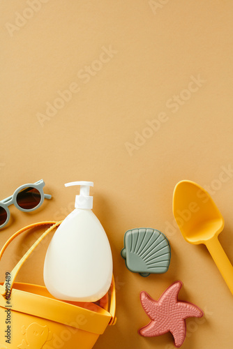 Silicone beach toys and suntan lotion for kids on beige background. Flat lay, top view.