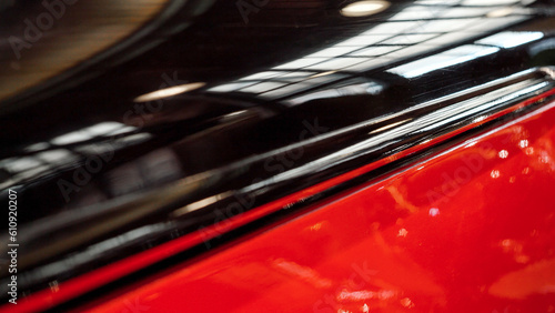 Glossy polished surface of vintage car painted in black and red