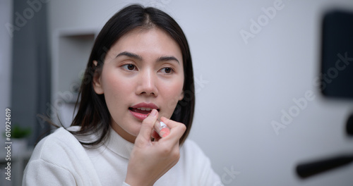 Beautiful young Asian woman blogger shows how to make up cosmetics at home