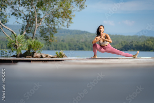 Fitness Asian woman doing yoga in park, Young woman practicing yoga, female happiness in landscape background, Lifestyle of exercise and pose for relax healthy life in the morning nature outdoor © chokniti