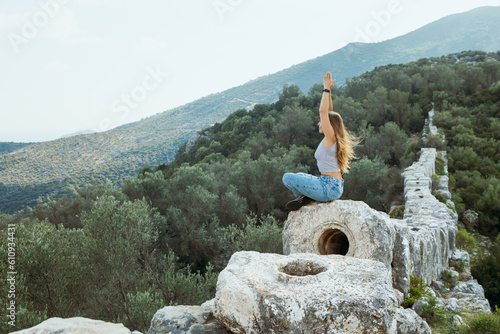 Woman relax in yoga pose at ruins of Delikkemer aqueduct photo