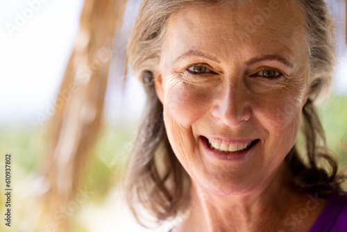 Close-up portrait of happy caucasian beautiful senior woman with brown eyes looking at camera