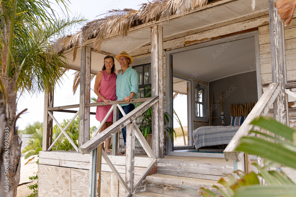 Caucasian happy senior couple standing by railing in balcony at wooden cottage, copy space Caucasian happy senior couple standing by railing in balcony at wooden cottage, copy space