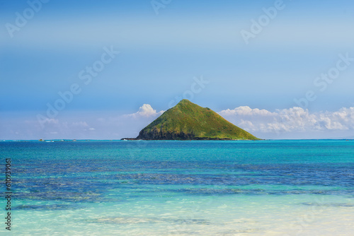Tropical, island and ocean with sky or sunshine for vacation in hawaii or nature for calm, relax in outdoor. Travel, holiday and tropic with sea or mountain in summer for adventure with clouds.