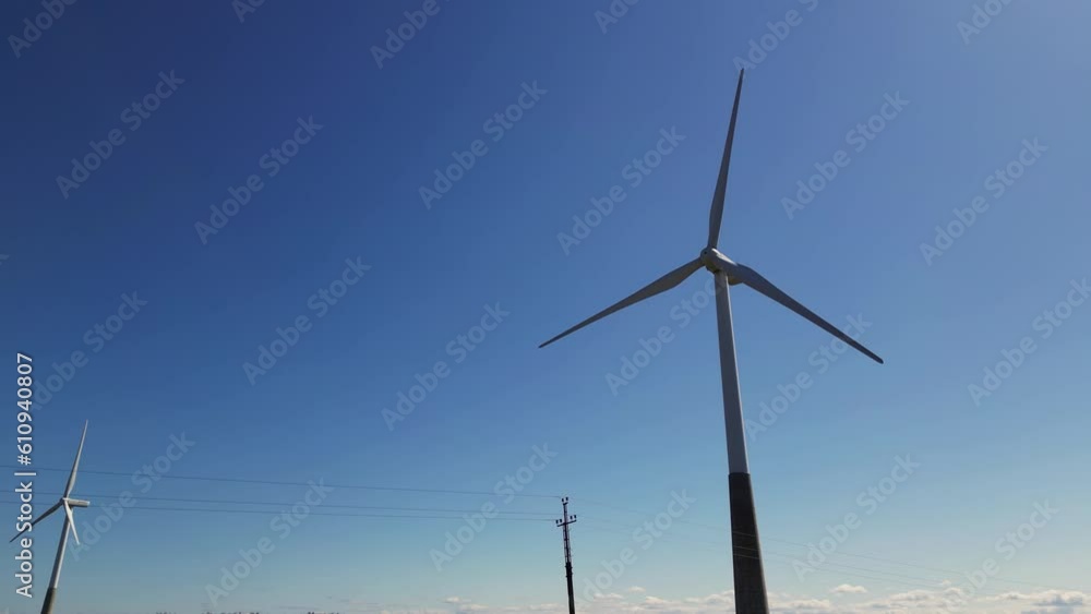 Large wind turbines with blades in field aerial view. Wind farm generating green energy. Renewable energy. Green tech. Rotating blades of a wind turbine, Solar power plant and Windmills aerial view. Large wind turbines with blades in field aerial view. Wind farm generating green energy. Renewable energy. Green tech. Rotating blades of a wind turbine, Solar power plant and Windmills aerial view.