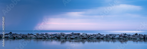 Obraz na płótnie Breakwater built of stones. Long exposure photo. The Baltic Sea just before the storm. w salonie