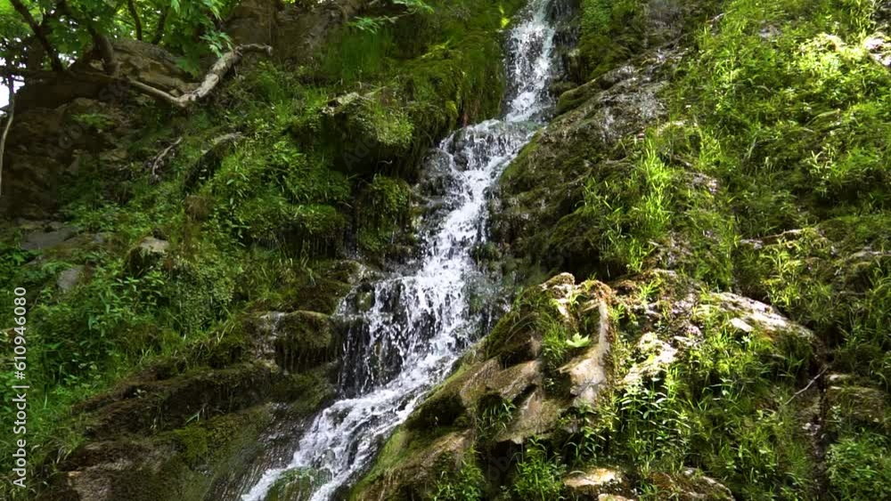 Slow Motion Of Maries Waterfall, Surrounded By Lush Green Vegetation And Rocks Covered By Moss, Sun Rays, Thassos Island, Greece Slow Motion Of Maries Waterfall, Surrounded By Lush Green Vegetation And Rocks Covered By Moss, Sun Rays, Thassos Island, Greece