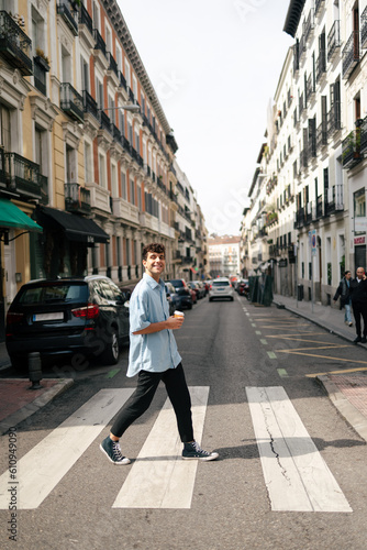 Young man crossing the road in city © Imanol