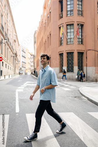 Young man crossing the road in the city