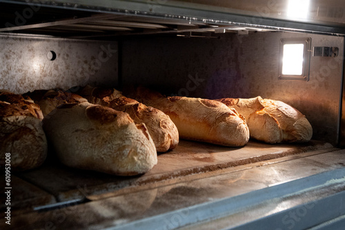 Baked bread slides into the mouth of the oven ready to be taken out of the oven