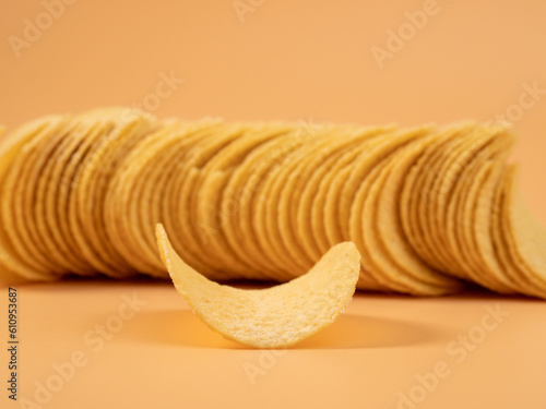 Delicious potato chips on an orange background. Potato chips close up.