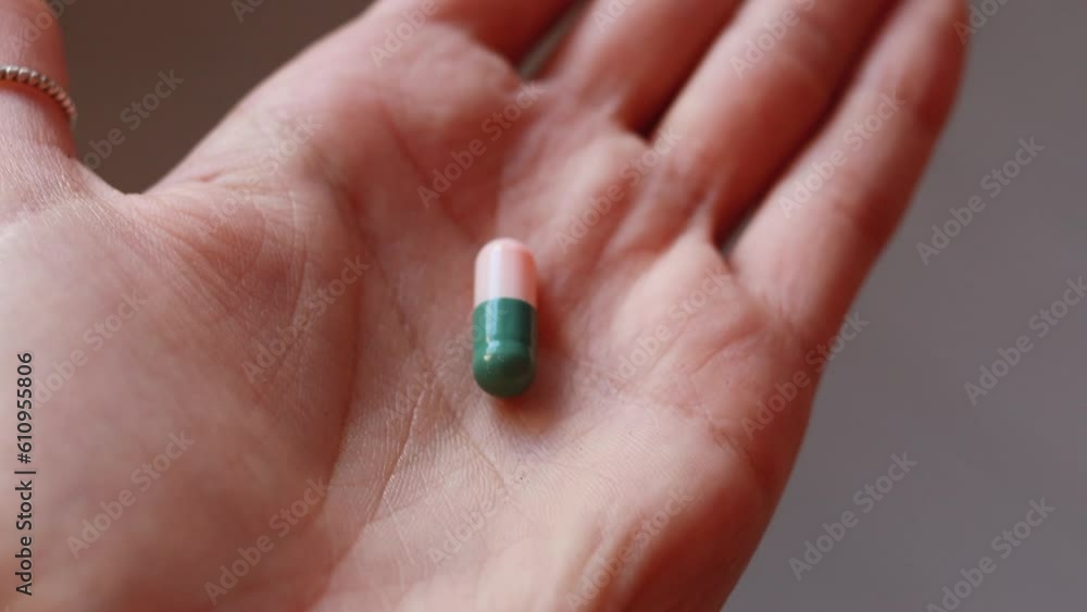 A girl holding a pill in the palm of her hand - camera approach A girl holding a pill in the palm of her hand - camera approach