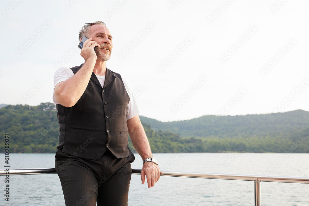 elderly man talking by smartphone in luxury yacht elderly man talking by smartphone in luxury yacht
