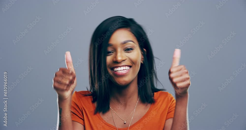 Thumbs up, excited and face of woman in studio for goal achievement, agreement or success. Happy, smile and portrait of African female model with an approval hand gesture isolated by gray background. Thumbs up, excited and face of woman in studio for goal achievement, agreement or success. Happy, smile and portrait of African female model with an approval hand gesture isolated by gray background.