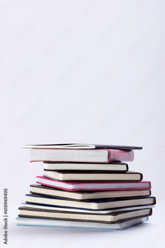 Close up of stack of books and notebooks with copy space on white background Close up of stack of books and notebooks with copy space on white background