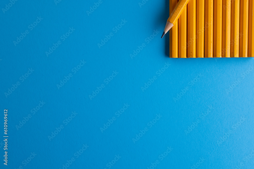 Close up of yellow pencils and copy space on blue background Close up of yellow pencils and copy space on blue background