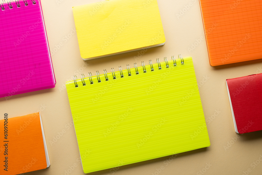 Multi coloured notebooks and copy space on orange background Multi coloured notebooks and copy space on orange background