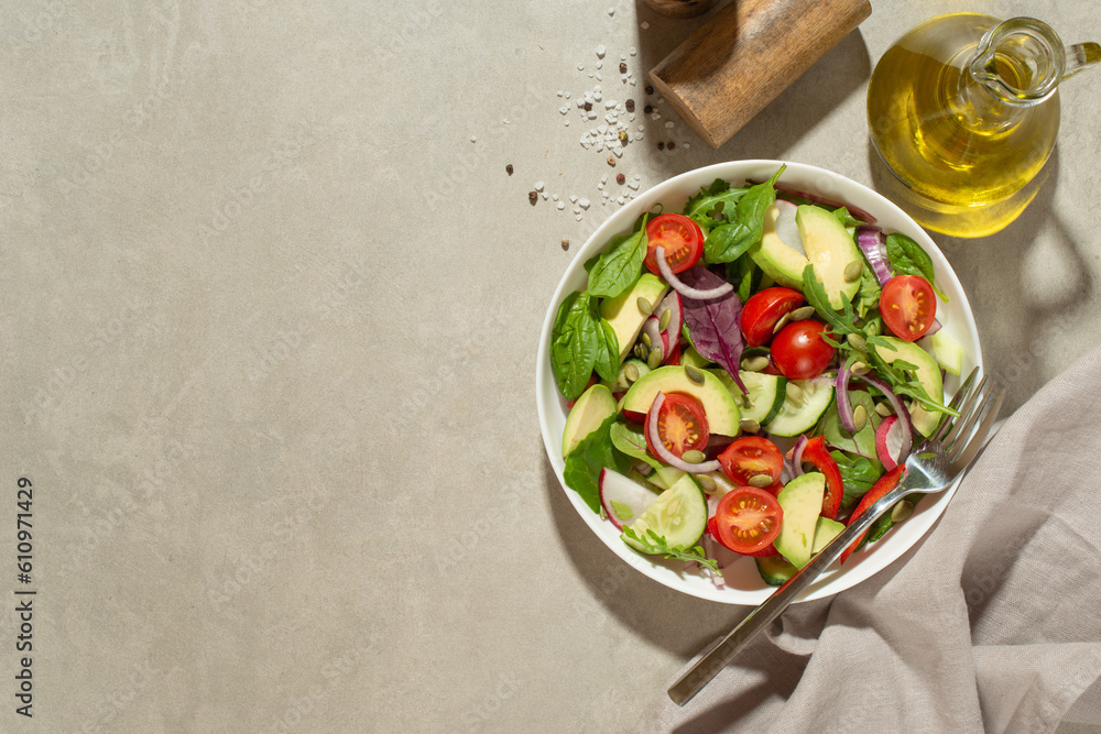 Vegetable salad with tomatoes, avocado and cucumber on a gray background Vegetable salad with tomatoes, avocado and cucumber on a gray background