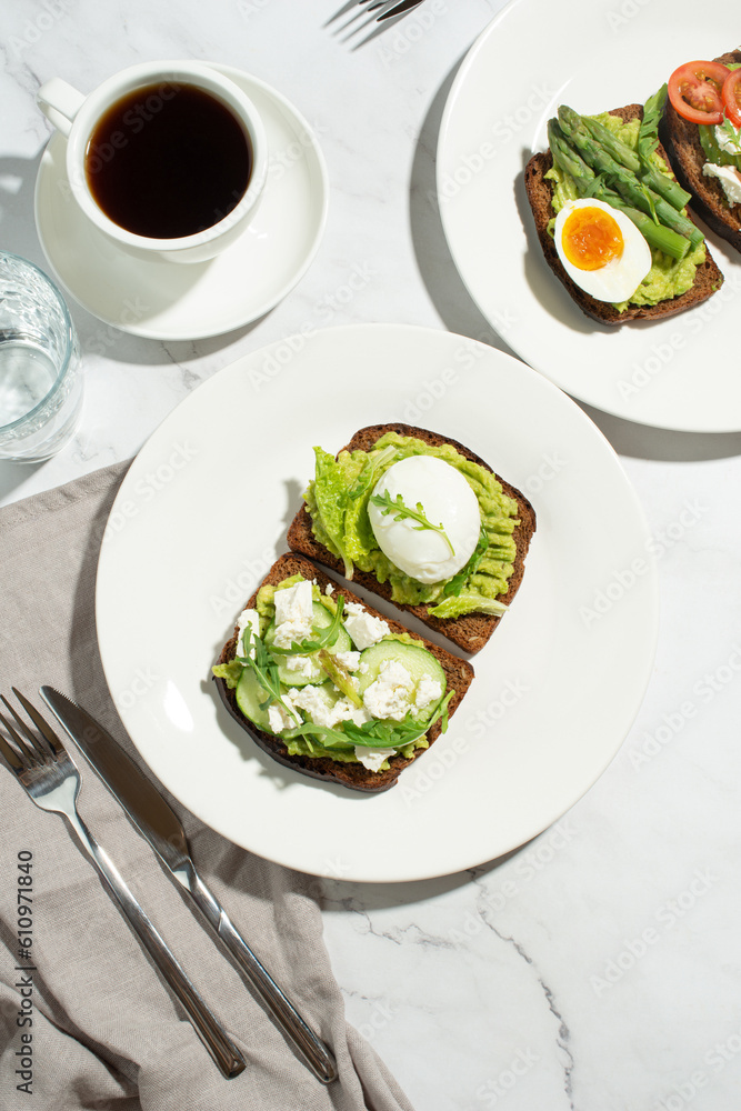 Breakfast with toast, avocado, eggs and vegetables on a gray background Breakfast with toast, avocado, eggs and vegetables on a gray background