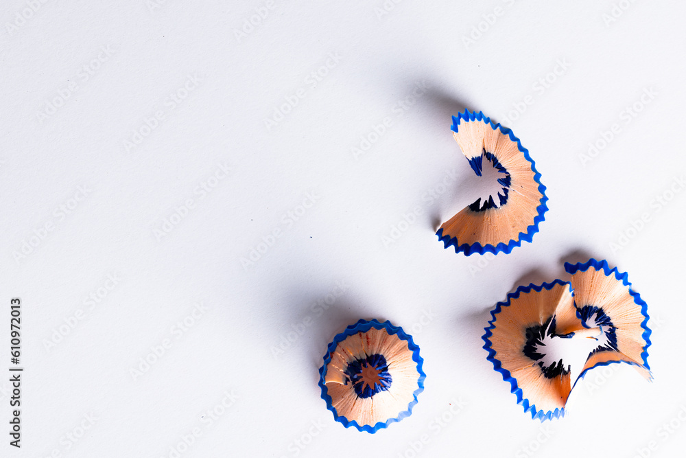 Close up of blue pencil shavings with copy space on white background Close up of blue pencil shavings with copy space on white background