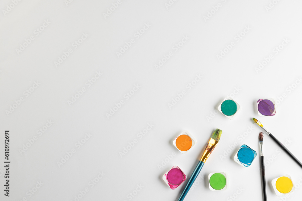 Close up of paints and brushes with copy space on white background Close up of paints and brushes with copy space on white background