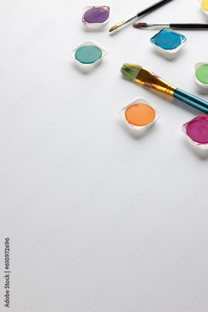 Close up of paints and brushes with copy space on white background Close up of paints and brushes with copy space on white background