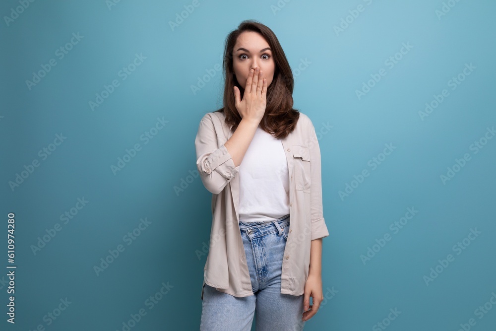 pretty european brunette young woman in a stylish look on a blue background with copy space pretty european brunette young woman in a stylish look on a blue background with copy space