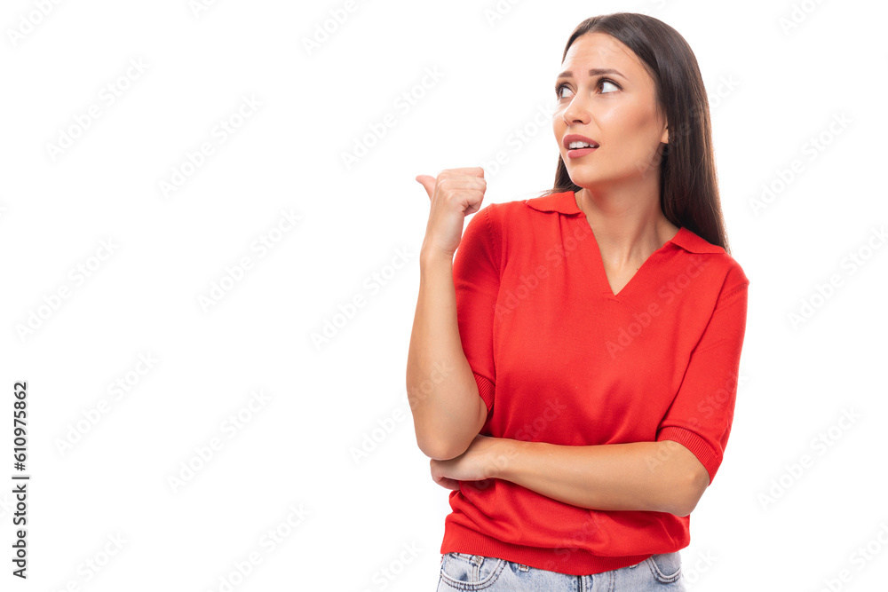 pretty smart caucasian woman with black hair is wearing a red blouse with a halter neckline pointing her finger at the advertising space pretty smart caucasian woman with black hair is wearing a red blouse with a halter neckline pointing her finger at the advertising space