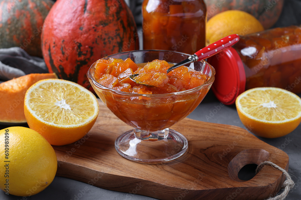 Homemade pumpkin jam with lemon and orange in transparent bowl and in jars - obrazy, fototapety, plakaty 