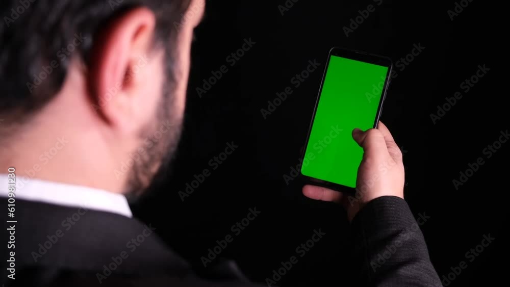 a man in black and white shirt scrolling on his phone a man in black and white shirt scrolling on his phone