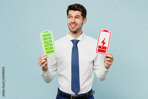 Young sad employee business man corporate lawyer wear classic formal shirt tie work in office hold in hand green red battary charge card isolated on plain pastel light blue background studio portrait. photo