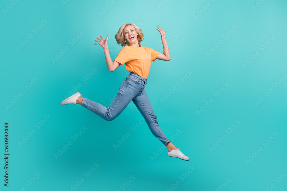 Full length photo of gorgeous positive person dressed yellow t-shirt jeans jumping having fun isolated on turquoise color background
