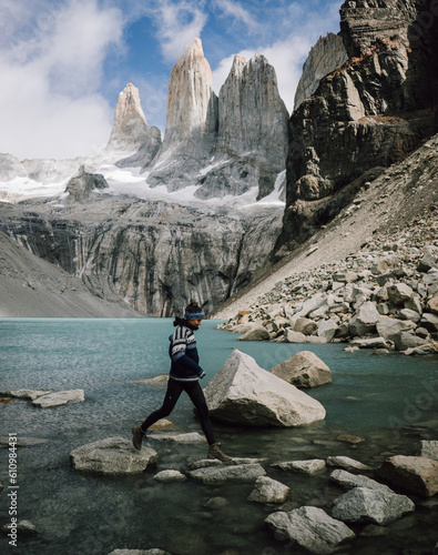 girl jumping on rocks at torre del paine, patagonia