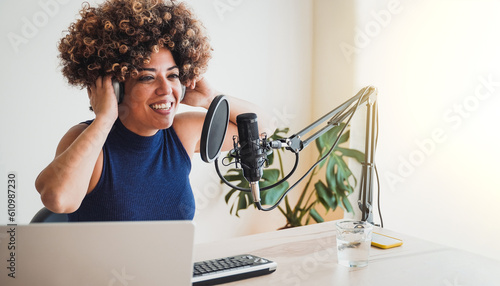 African host woman recording podcast at home studio - Business, podcaster technology - Focus on microphone photo