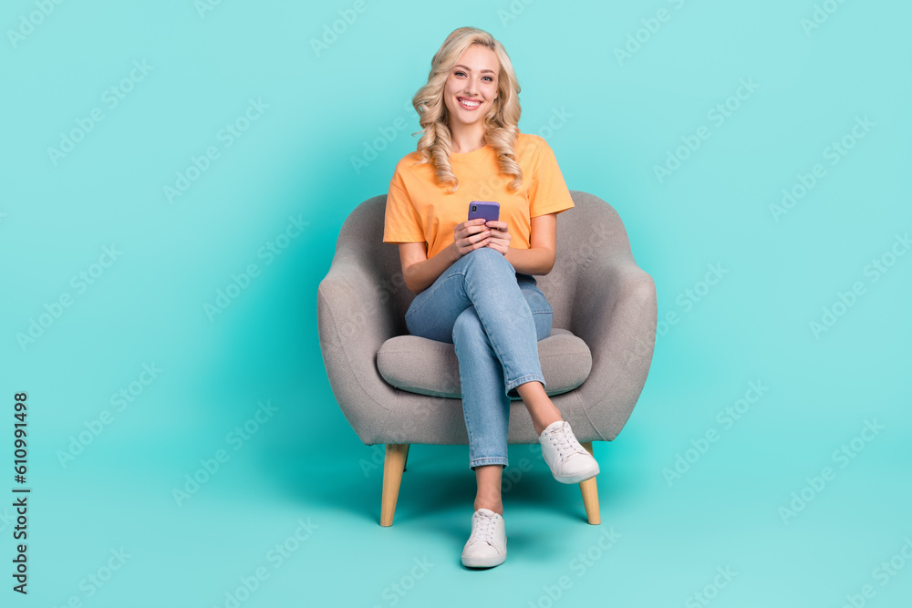 Full length photo of funky cute lady dressed orange t-shirt communicating apple samsung gadget isolated teal color background