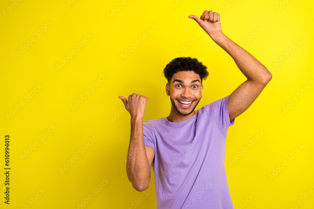 Photo of astonished nice person toothy smile direct fingers empty space novelty isolated on yellow color background Photo of astonished nice person toothy smile direct fingers empty space novelty isolated on yellow color background