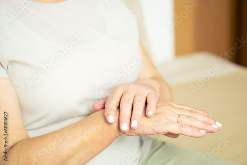 Close up of senior woman appllying hand cosmetic cream at home.