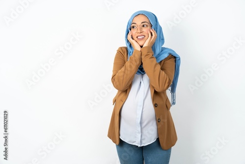 Inspired Young beautiful pregnant muslim woman wearing hijab over white background looking at copyspace having thoughts about future events