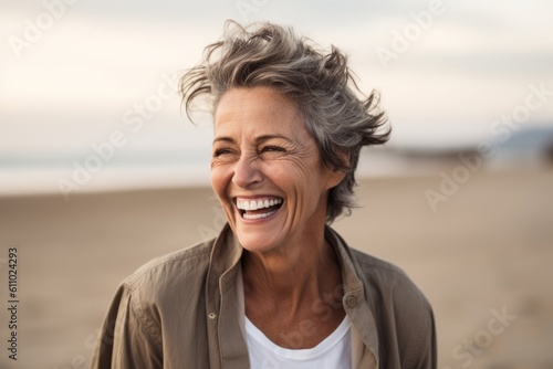 Medium shot portrait photography of a grinning mature woman laughing against a serene beach background. With generative AI technology