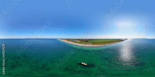 Luftaufnahme der beeindruckenden Landschaft von Westermarkelsdorf auf Fehmarn mit Deich, grünen Wiesen und Strand am blauen Ostseemeer: Malerisches Küstenjuwel photo