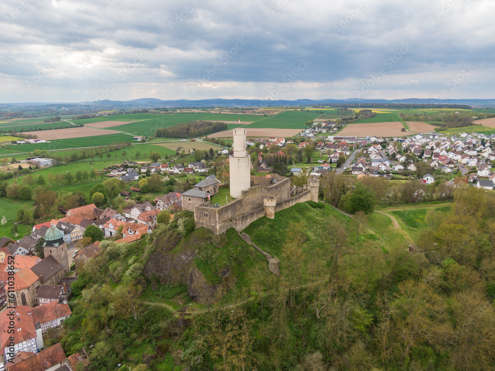 Majestätische Felsburg: Luftaufnahme der imposanten Burg in Hessen mit Bergkulisse, Burgturm, Burgmauer, Dörfern und Feldern im Hintergrund