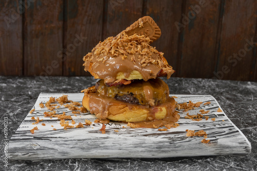 Detalle de una hamburguesa con carne, crema de cacahuetes, y galletas lotus