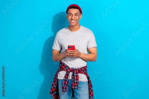 Photo of positive sweet guy dressed grey t-shirt communicating instagram twitter telegram facebook isolated blue color background