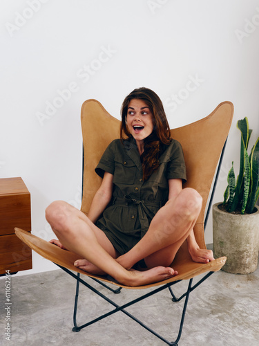 Woman model sits on a chair at home smile, fun and relaxation, modern stylish interior scandia lifestyle, copy space. photo