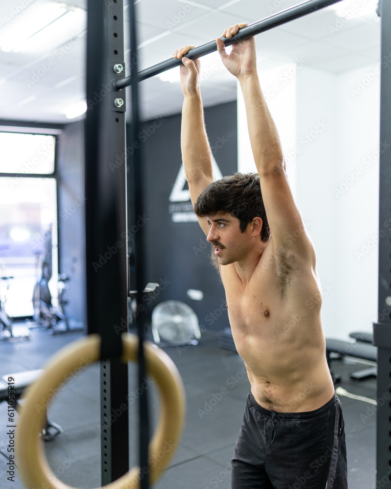 Fototapeta premium Shirtless, mustached adult man in good physical shape resting during his training at the training center.